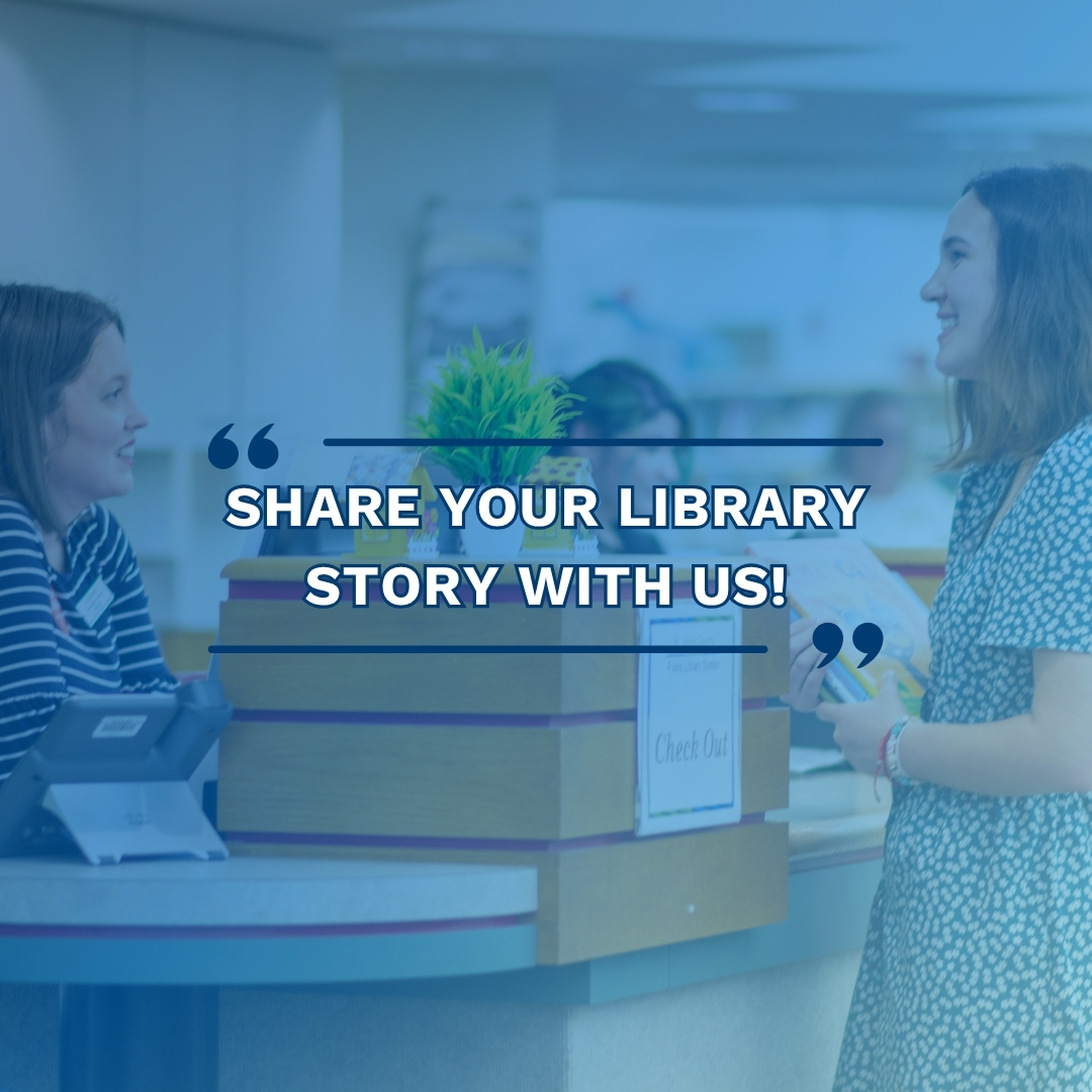 A librarian and a patron smiling near the circulation desk.
